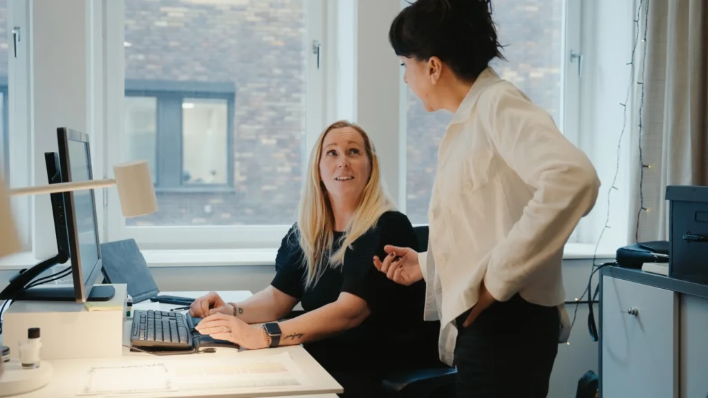 videoannonsering två kvinnor som diskuterar framför en dator