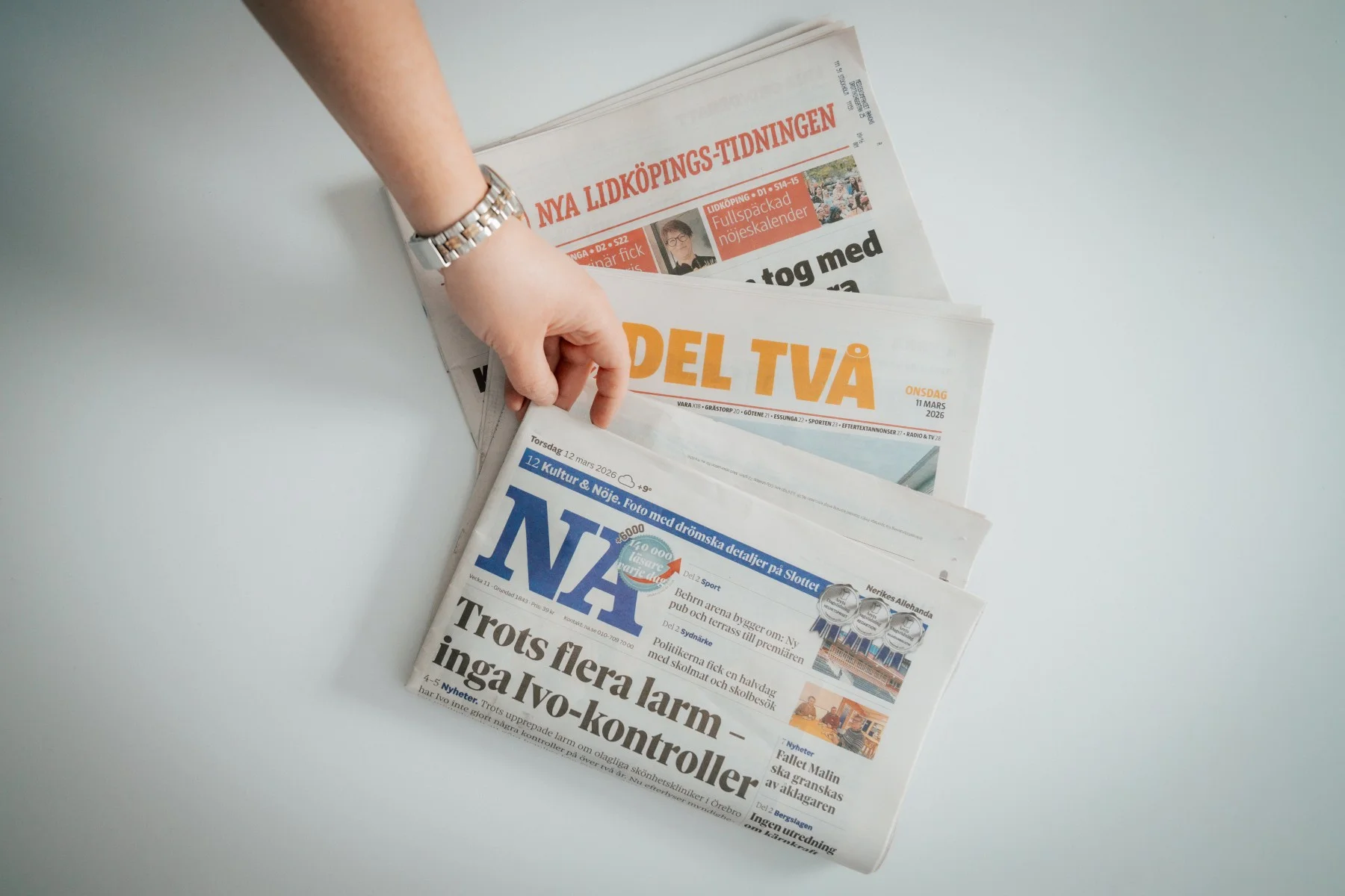 annonsering via print hand som håller i flera tidningar